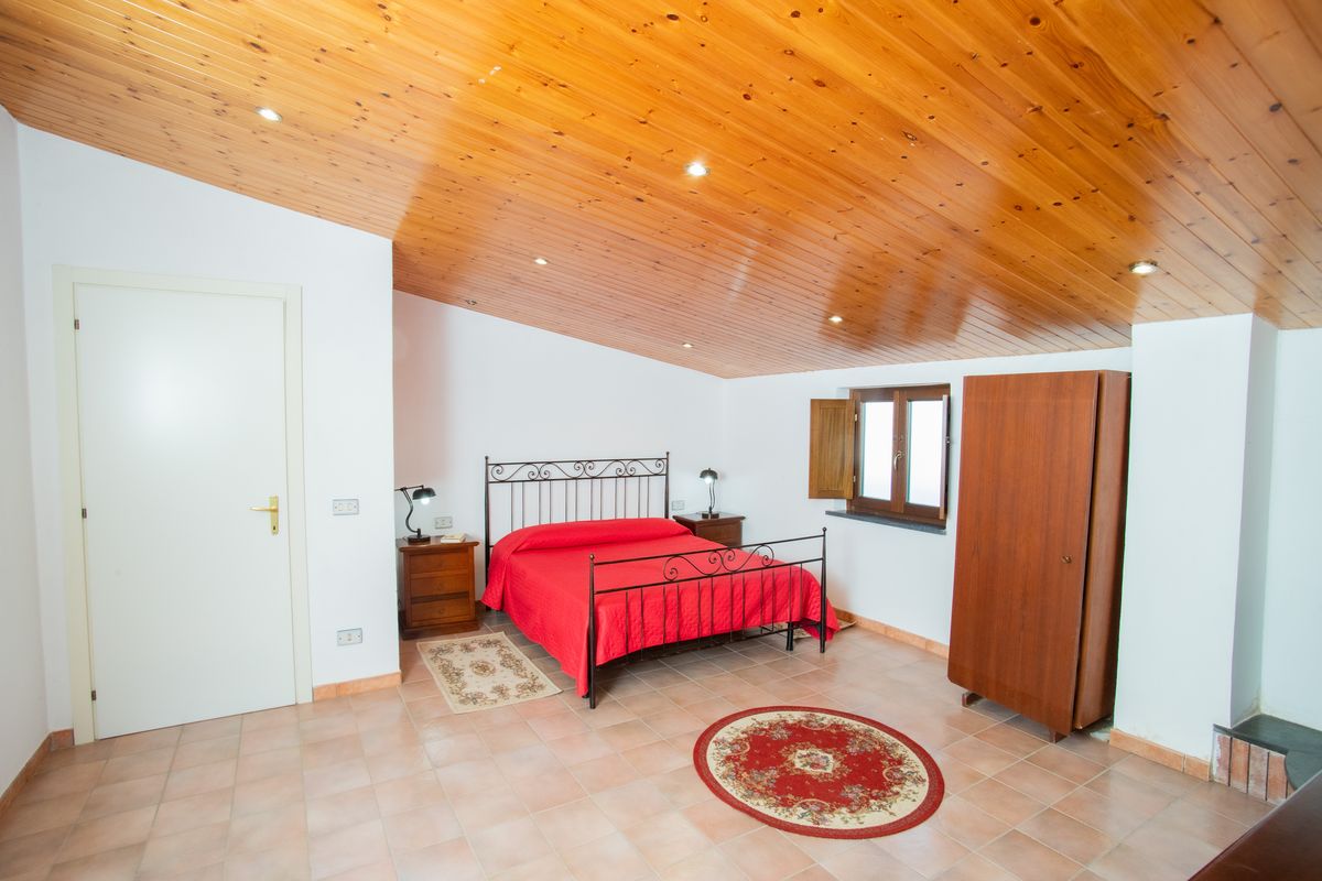 Suite ampia con soffitto in legno e zona relax